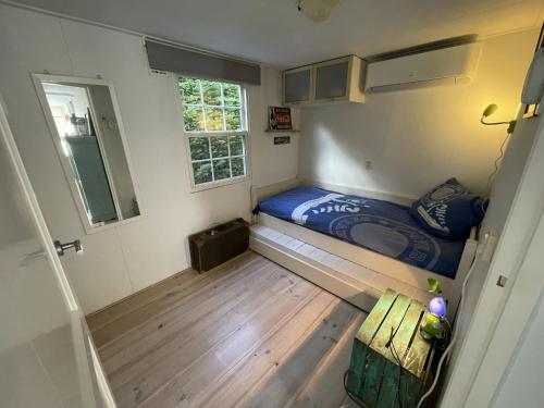 a small room with a bed and a window at Your Private Zeeland Getaway - Cosy Home With Large Garden in Heinkensand