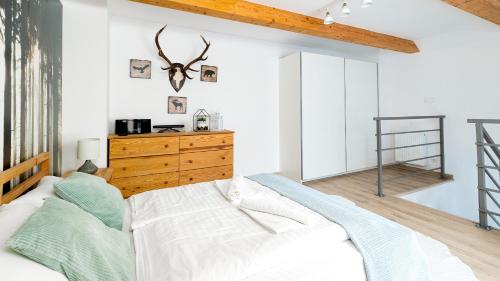 a bedroom with a bed and a wooden dresser at VacationClub - Sarnia Residence Apartament 35 in Karpacz