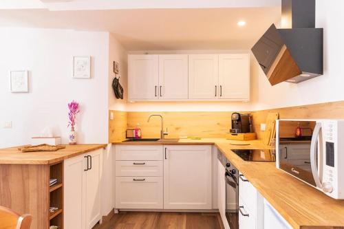 une cuisine avec des armoires blanches et un comptoir dans l'établissement Maison de village l'étoile d'Auré Moustiers, à Moustiers-Sainte-Marie