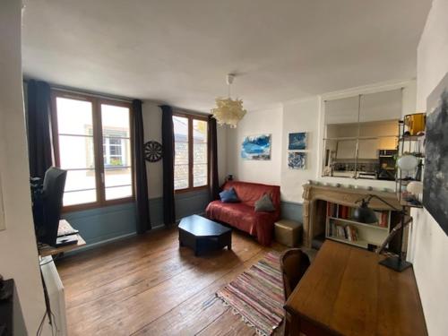 un salon avec un canapé rouge et une table dans l'établissement Studio Cosy plein centre-ville, à Strasbourg