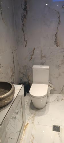 a bathroom with a white toilet and a marble wall at MONASTHRIOY PALLAS 3 By MAKHOME in Thessaloniki
