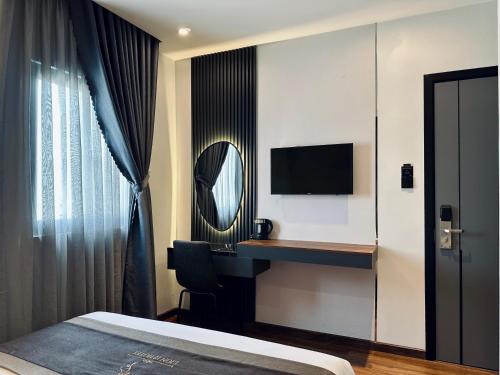 カントーにあるLION 12 Hotelの机と鏡のあるホテルの部屋