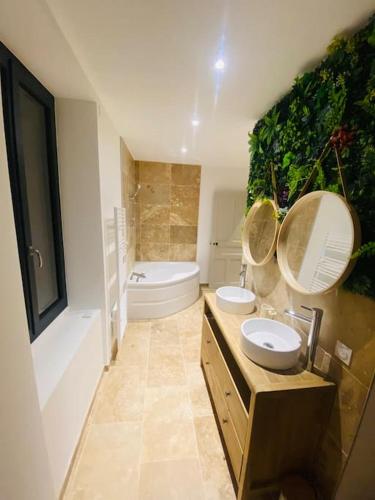 La salle de bains est pourvue de 2 lavabos, de toilettes et d'une baignoire. dans l'établissement Magnifique Maison 9 personnes à Valence, à Valence