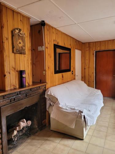 a bedroom with a bed and a fireplace at Avenida Centro in Los Antiguos
