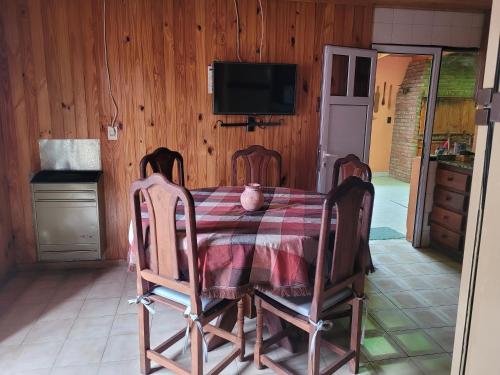 a dining room with a table and chairs and a television at Avenida Centro in Los Antiguos