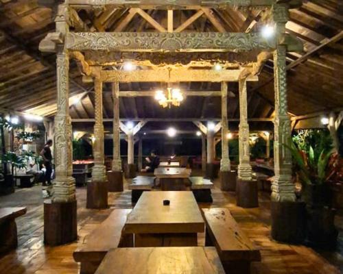 a large room with wooden tables and a chandelier at Warung Rekreasi Bedugul in Bedugul