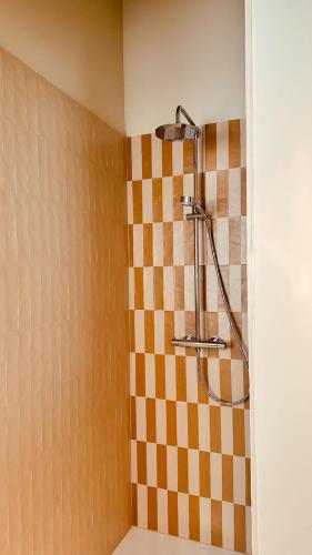 a shower in a bathroom with a checkered wall at Staf Vakantiewoning 8 ps De Haan centrum in De Haan
