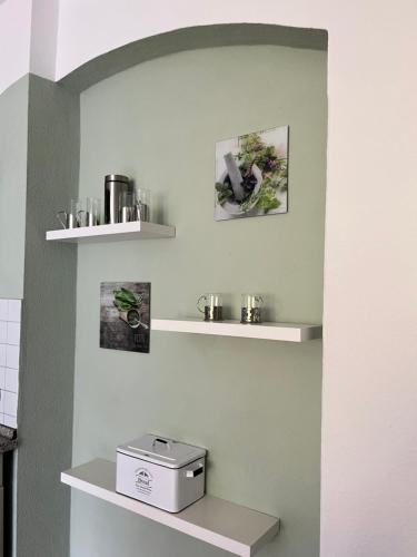 a kitchen with white shelves on the wall at Apartment mit Balkon & Parkplatz in Meißen