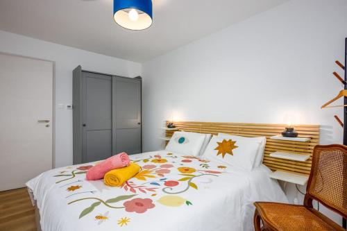 une chambre avec un lit blanc avec des fleurs dessus dans l'établissement Les Iris Blancs, à Orbey