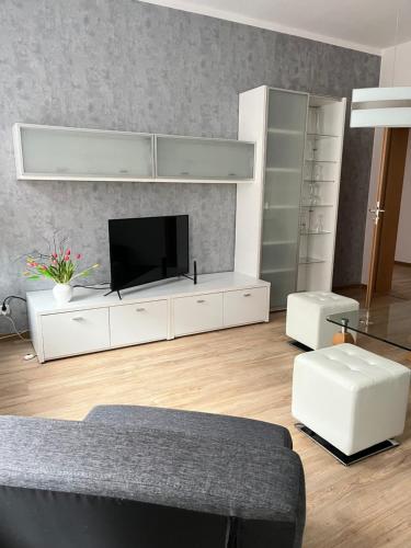 a living room with a large white entertainment center with a tv at Apartment mit Balkon & Parkplatz in Meißen