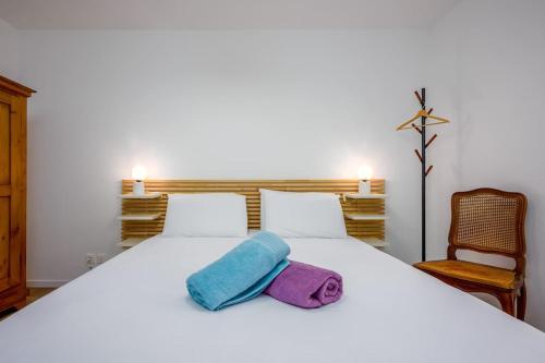 a white bed with a towel on top of it at Les Iris Blancs in Orbey