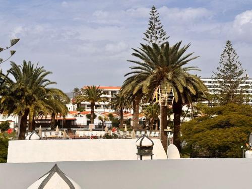 a view of a resort with palm trees and a building at Yumbo Rainbow Homes D in Maspalomas