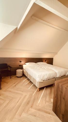 a bedroom with a large bed in the attic at Staf Vakantiewoning 8 ps De Haan centrum in De Haan