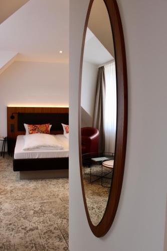 a bedroom with a bed and a mirror at Hotel Alma Am Anger in Erfurt