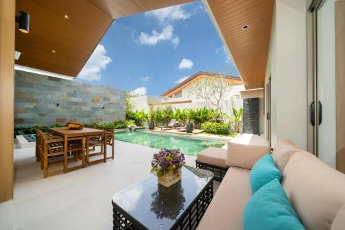 a living room with a couch and a table at Villa private swimming pool and garden in Phuket Town