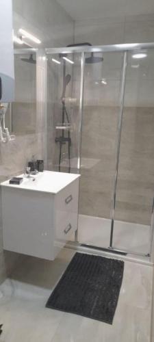 un bagno con doccia e lavandino bianco di Apartment T & P a Krapina