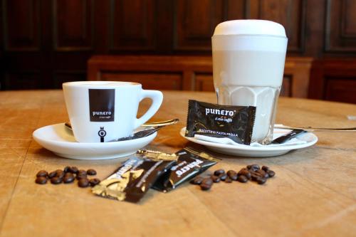 a table with a cup of coffee and some coffee beans at Hotel Alma Am Anger in Erfurt