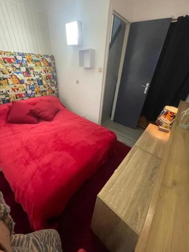 - une chambre avec un lit rouge et un banc en bois dans l'établissement Maison familiale avec terrasse à Vieille-Brioude, à Vieille-Brioude