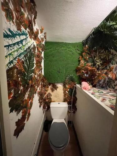 Elle comprend une petite salle de bains pourvue de toilettes et d'un mur vert. dans l'établissement Maison familiale avec terrasse à Vieille-Brioude, à Vieille-Brioude