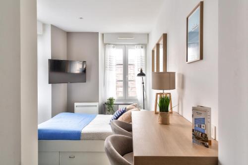 a small bedroom with a bed and a desk at STUDIOS cosy Quartier Harteloire proche centre-ville in Brest