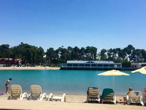 a group of chairs and umbrellas on a beach at Room Antonia in Umag