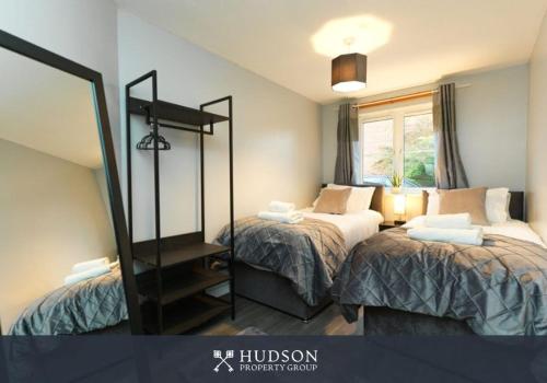 a bedroom with two beds and a mirror at Telford 2-Bedroom Apartment in Telford
