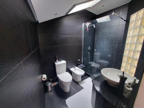 a black bathroom with a toilet and a sink at Casa Pico Musica in Funchal