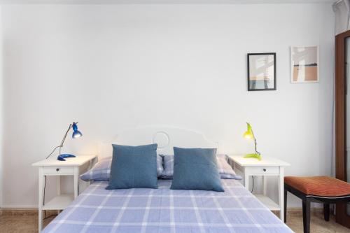 una camera con un letto blu e due tavoli bianchi di Home2Book Ocean Park Cozy Apt with Pool, Adeje ad Adeje