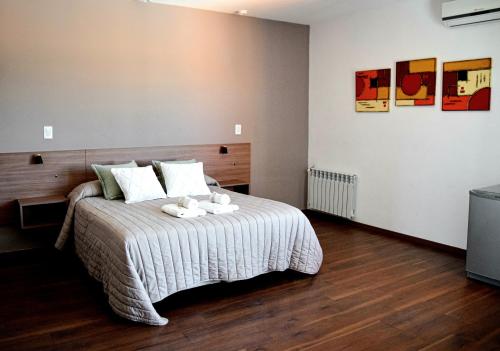 a bedroom with a bed with two stuffed animals on it at Alamo Hotel in Villa Carlos Paz