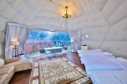 a room with four beds and a table in it at Ducale Garden Hotel Kujukuri in Kujukuri