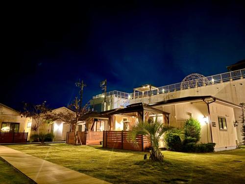 a house with a balcony on top of it at night at Ducale Garden Hotel Kujukuri in Kujukuri