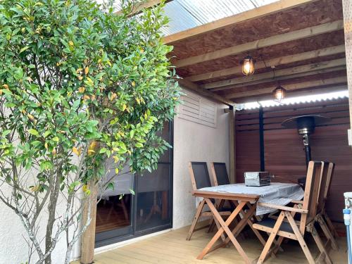 a wooden table and chairs on a patio at Ducale Garden Hotel Kujukuri in Kujukuri