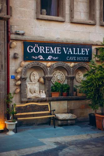 a sign on a building with a bench in front at Goreme Valley Cave House in Göreme