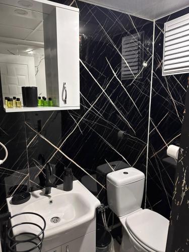 a black and white bathroom with a sink and a toilet at NIGRUM HOTEL in Nevsehir