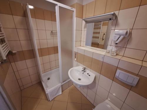 a bathroom with a sink and a shower at Politechnika Warszawska Ośrodek Wypoczynkowy in Sarbinowo