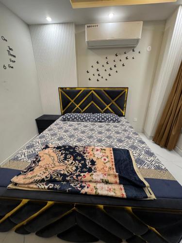 a bedroom with a bed with a quilt on it at Mehar Heights in Rāmkot