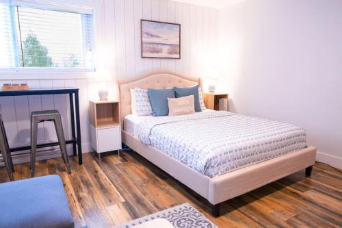 a bedroom with a bed with blue pillows and a fireplace at Harrison Lake Retreat, Studio Suite in Harrison Hot Springs