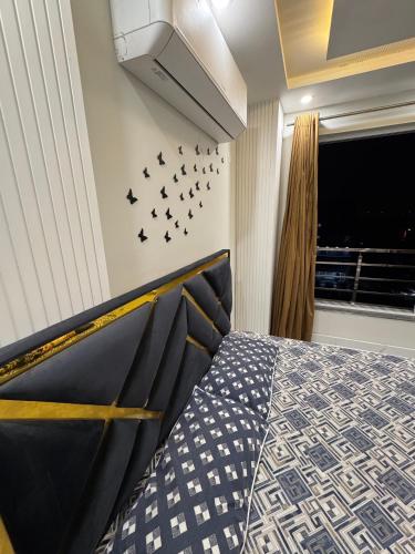 a bedroom with a bed with birds on the wall at Mehar Heights in Rāmkot