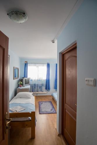 a room with a bedroom with a bed and a door at Barátság Panzió - Pensiunea Barátság in Ditrău