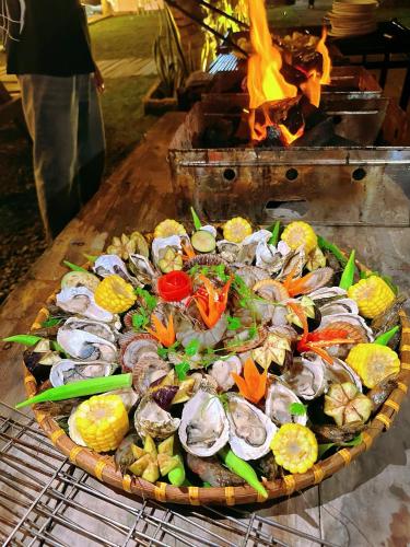 un plato de marisco y verduras a la parrilla en Waikiki Lagi Beach homestay & restaurant, en La Gi