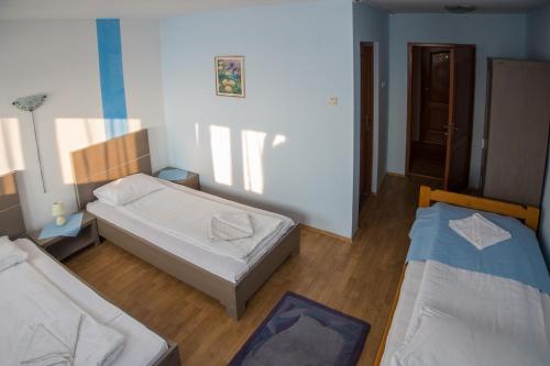 a room with two beds in a room at Barátság Panzió - Pensiunea Barátság in Ditrău