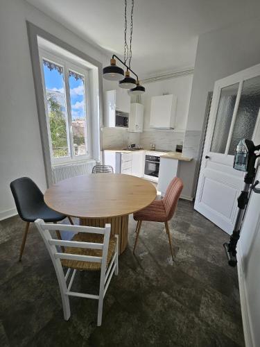 - une cuisine avec une table et des chaises en bois dans la chambre dans l'établissement Appartement F2 à Villeurbanne, à Villeurbanne