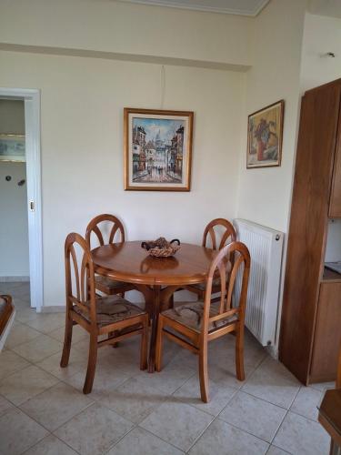 a wooden table and chairs in a room at Χαρά in Velimákhion