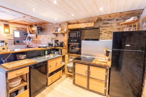 a kitchen with a black refrigerator and a stove at Gite lou clapas 5 personnes in Mas-dʼOrcières