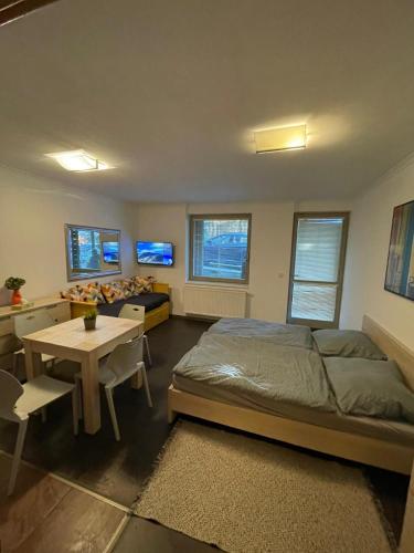 a bedroom with a bed and a desk and a table at Apartman Harrachov - Resident in Harrachov