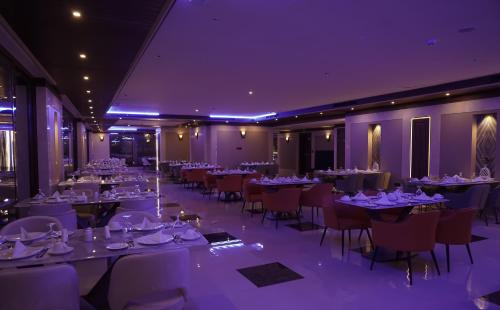 a dining room with tables and chairs and purple lighting at La Zona Continental Hotel in Dubai