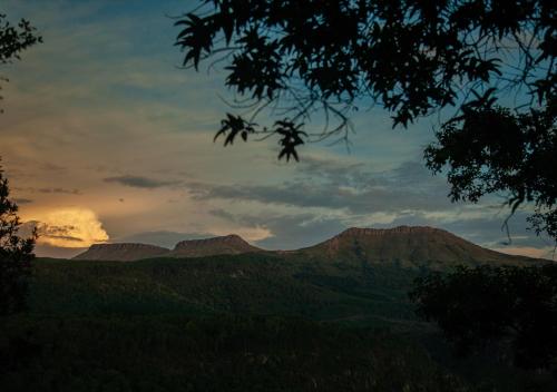 a view of a mountain range with the sunset in the background at Away with the Fairies Nature Lodge and Backpackers in Hogsback