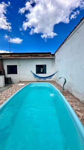a blue swimming pool in front of a building at Recanto Mãe Aparecida in Aparecida
