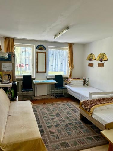 a room with two beds and a table and chairs at China-Ferienzimmer in Berchtesgaden