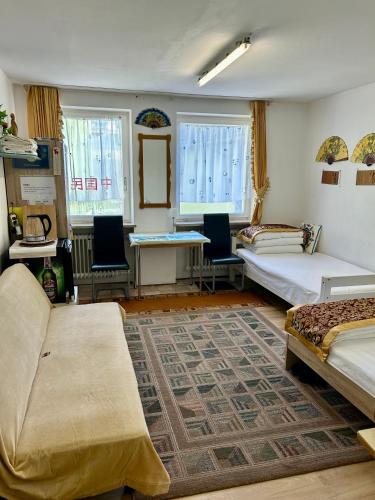 a room with two beds and a table and chairs at China-Ferienzimmer in Berchtesgaden